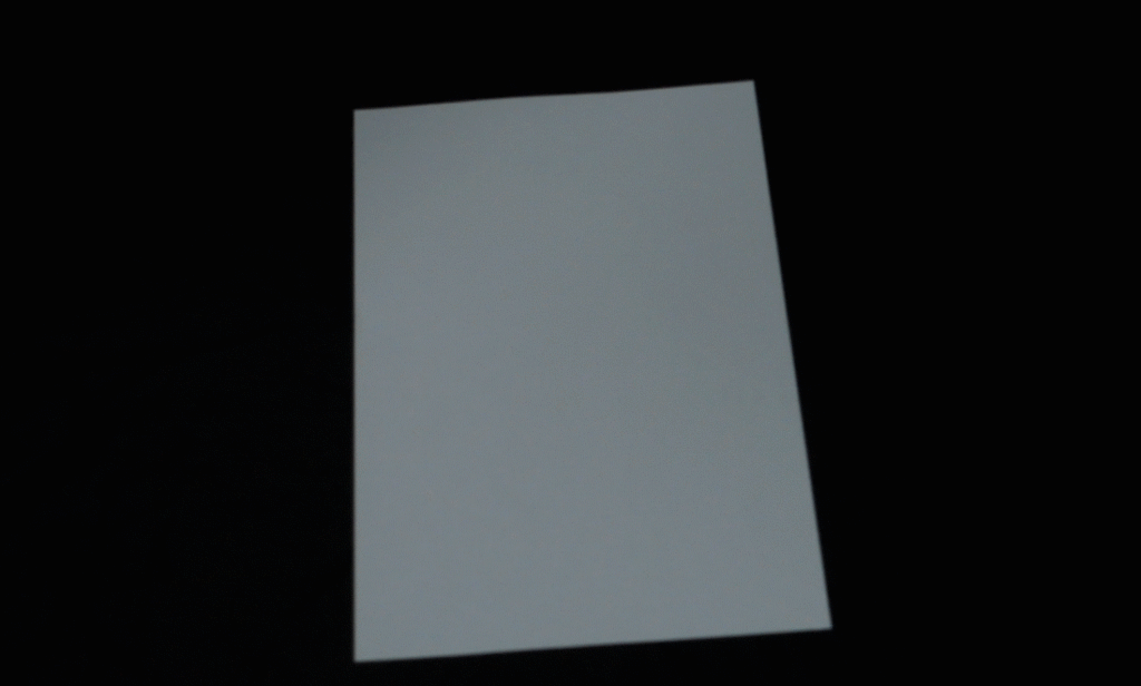 Demonstration of how to fold a sheet of white paper into a paper glider