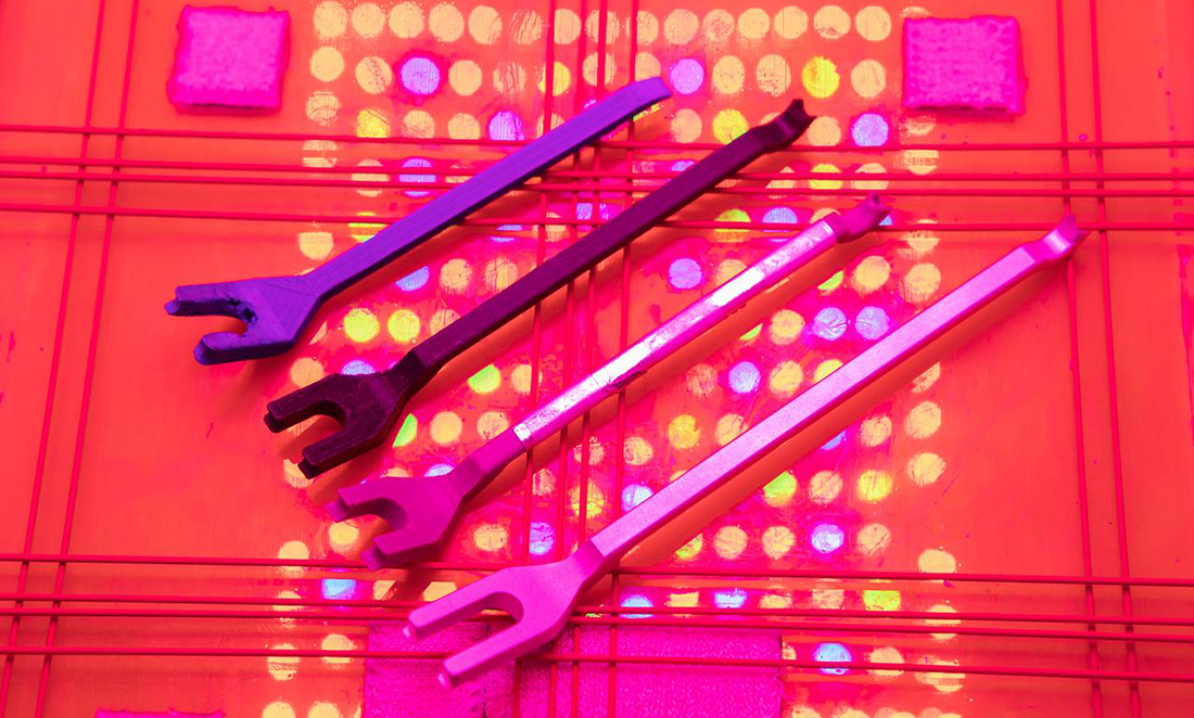 Four examples of NASA's 'bungee tool' which looks like a 2-pronged fork in different colours of pink and purple
