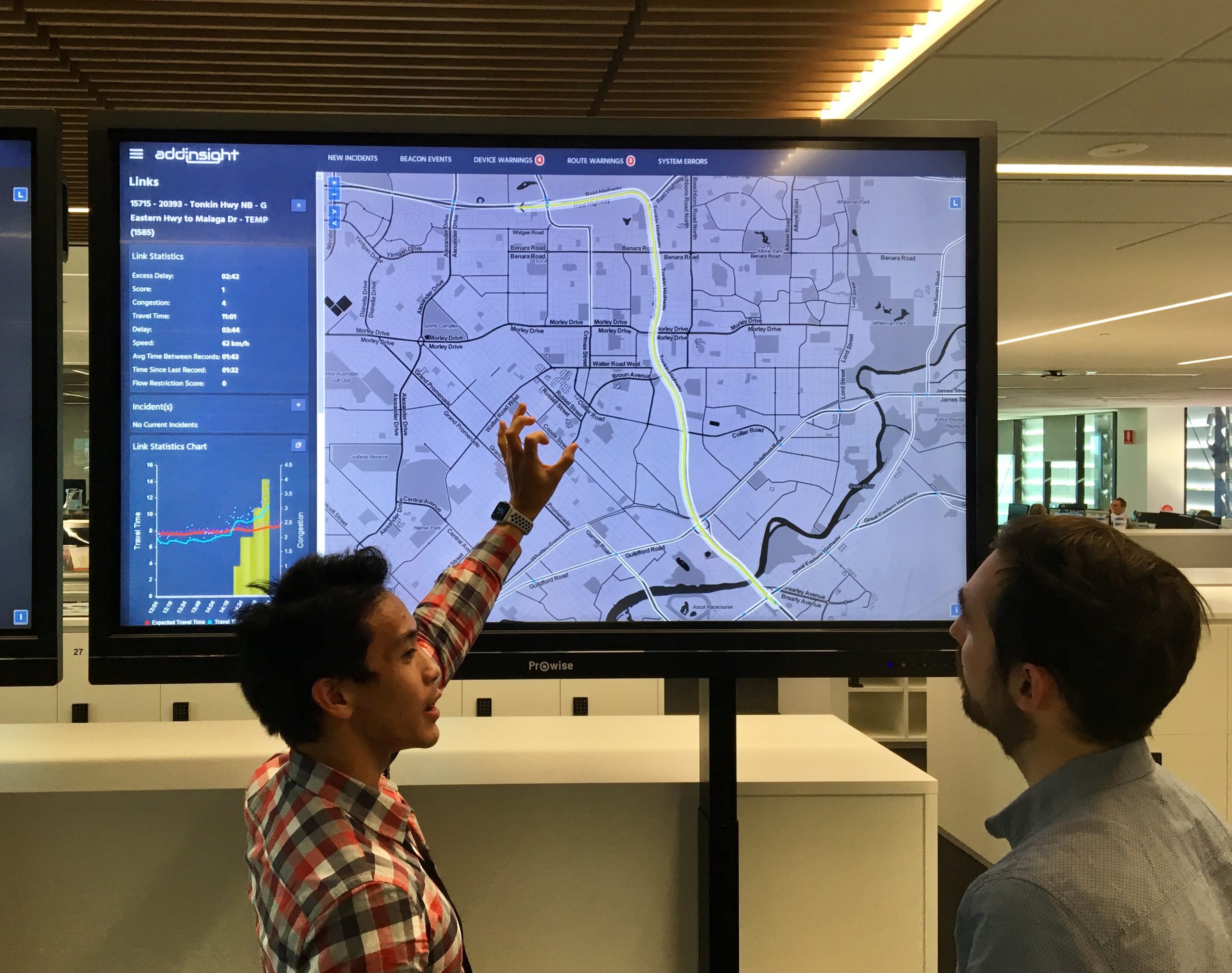 Staff look at a map of Perth, with traffic visible in yellow.