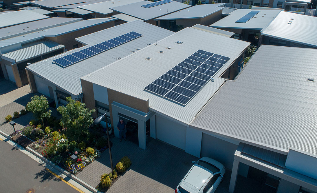 Drone photo of suburban rooftops with solar panels on them