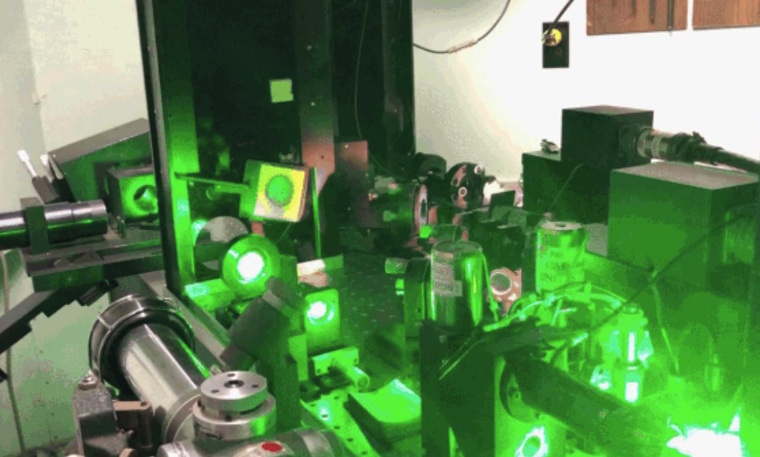 Equipment at the Yarragadee Observatory lit in green from their lasers
