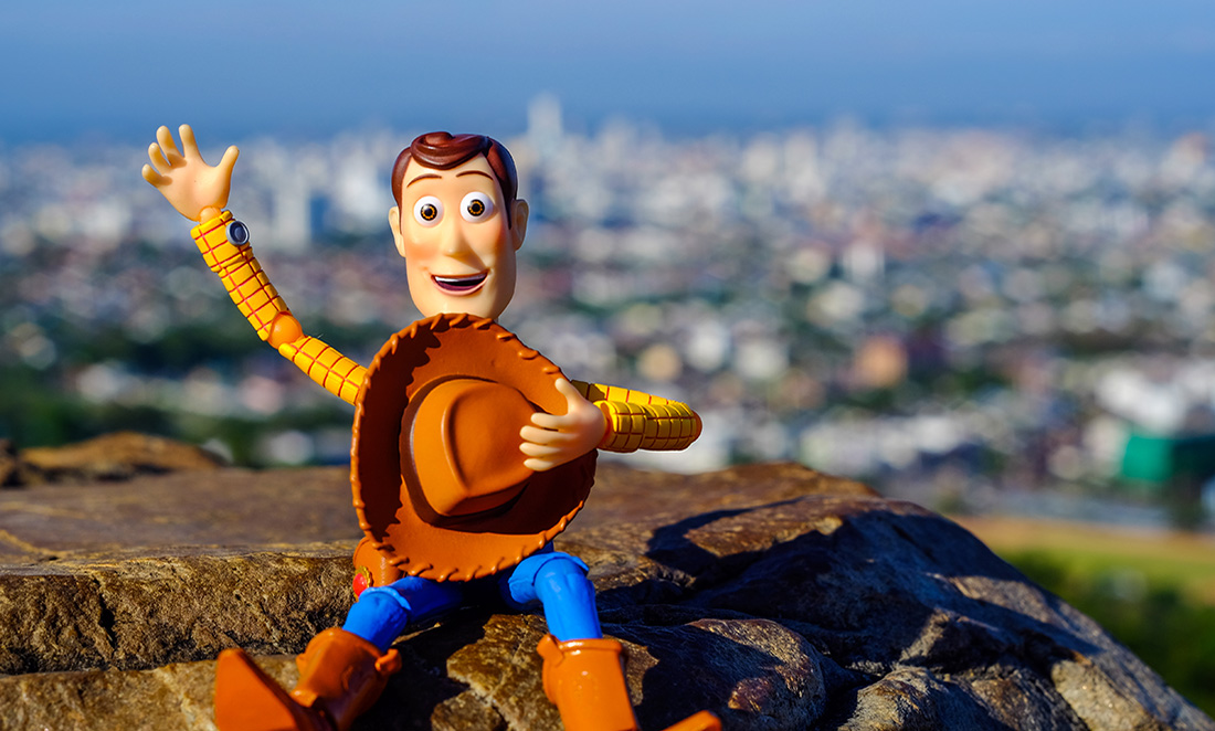 A 'Toy Story' Woody figurine posed in front of out-of-focus scenery
