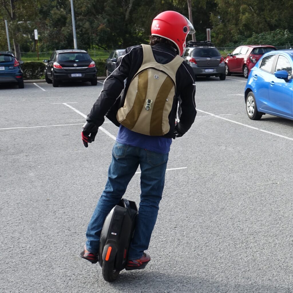 Phil with a backback on an electric unicycle