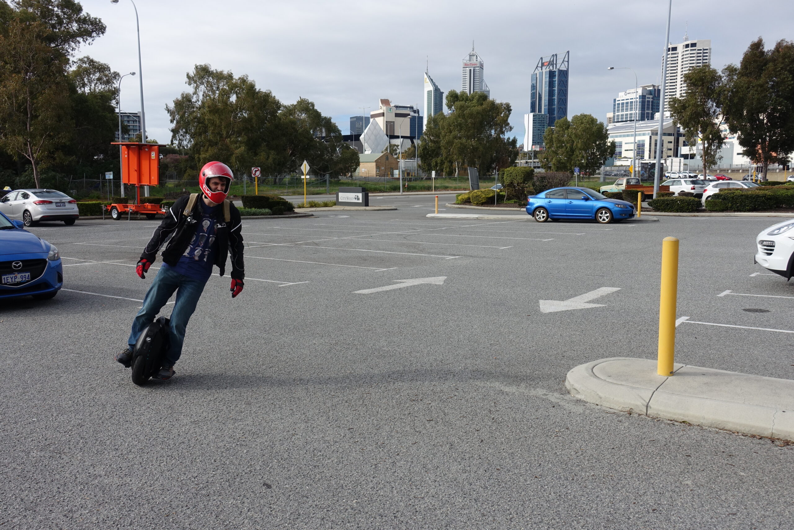 Phil rides an electric unicycle through a carpark outside the Perth CBD
