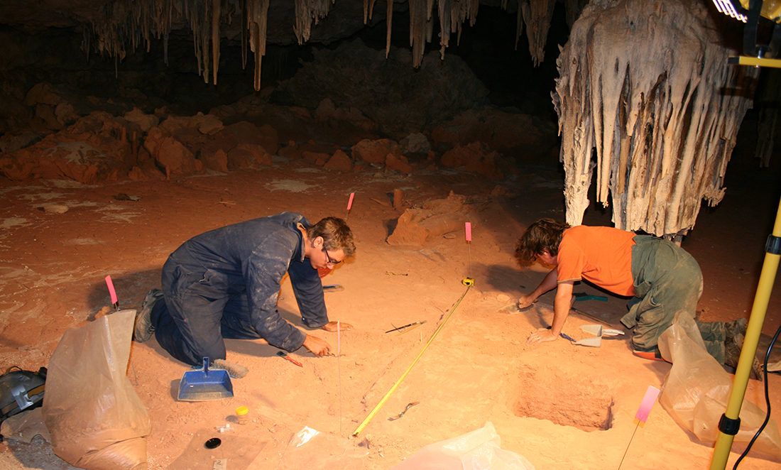 Professor Morten Allentoft searching through red sand, looking for extinct megafauna in a Nullarbor cave