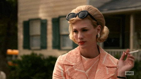 A gif from Mad Men showing Betty Draper (played by January Jones) smoking a cigarette and adjusting her sunglasses
