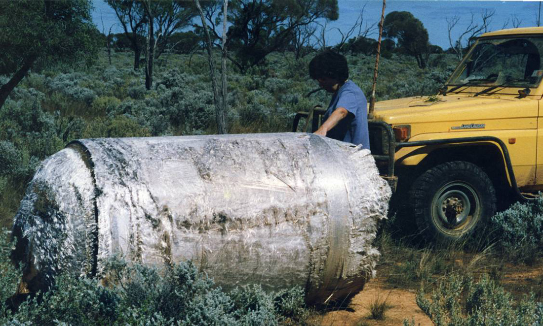 A man inspects a large silver chunk of Skylab landing near Norseman, Western Australia