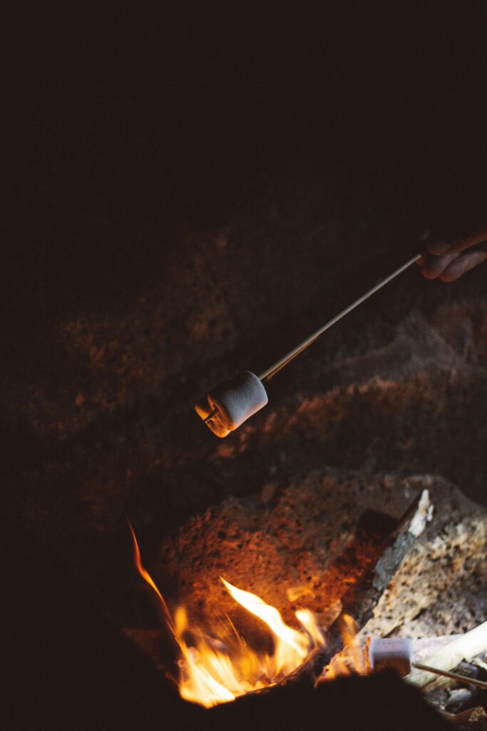 A photo of a marshmallow on a stick roasting over a fire